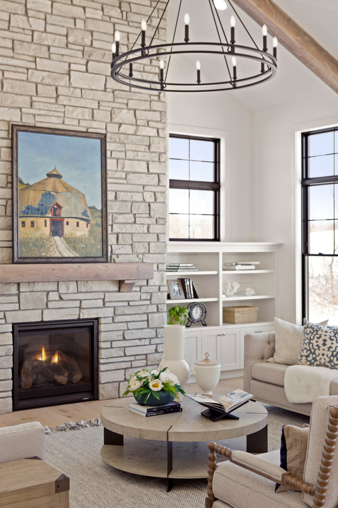 ミネアポリスにある巨大なトランジショナルスタイルのおしゃれなLDK (白い壁、淡色無垢フローリング、標準型暖炉、石材の暖炉まわり、三角天井) の写真