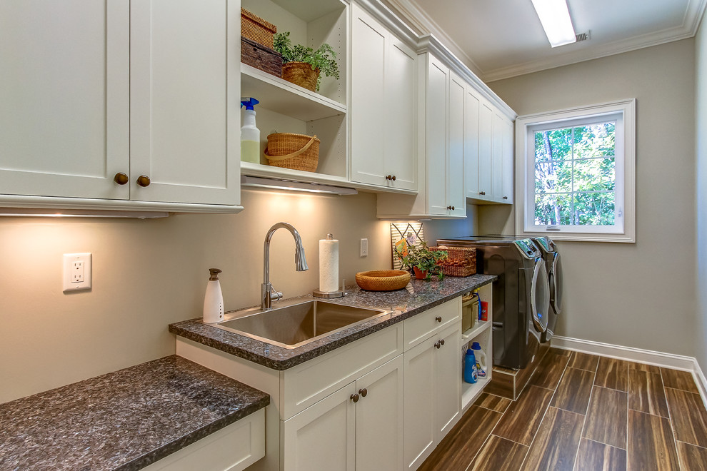 Inspiration for a mid-sized transitional single-wall porcelain tile dedicated laundry room remodel in Orange County with a drop-in sink, shaker cabinets, white cabinets, granite countertops, gray walls and a side-by-side washer/dryer