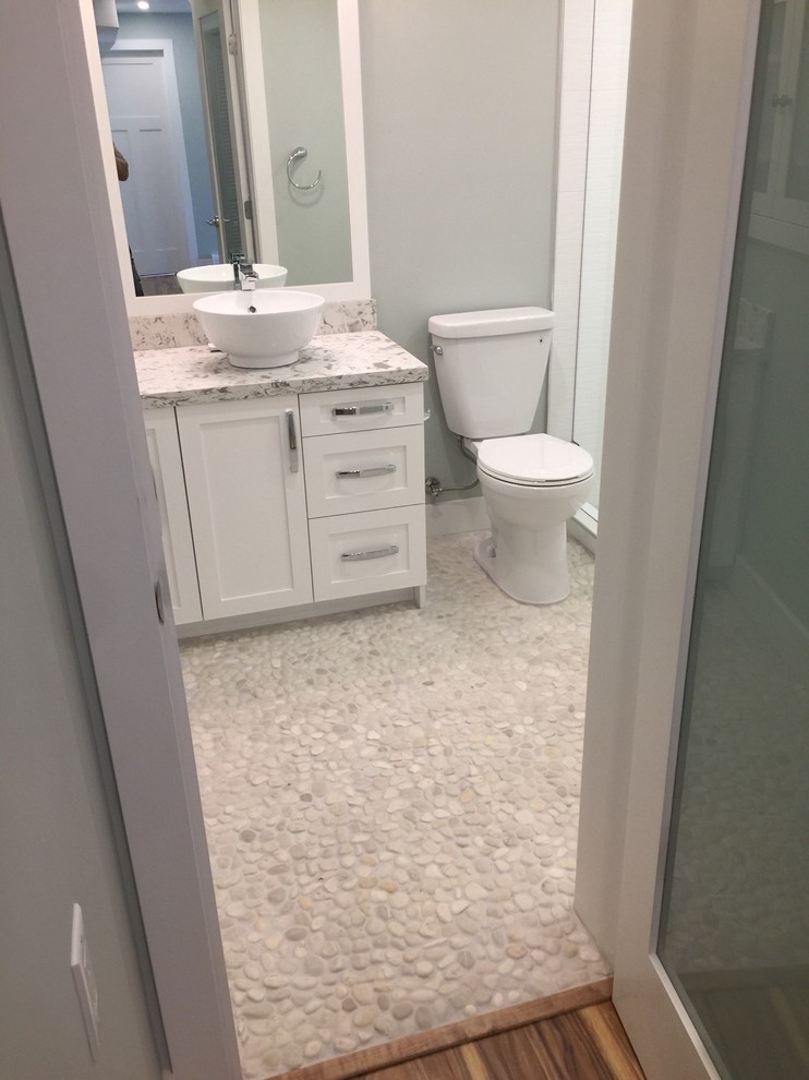 Photo of a contemporary bathroom in Vancouver with shaker cabinets, white cabinets, a two-piece toilet, pebble tile, pebble tile floors and engineered quartz benchtops.