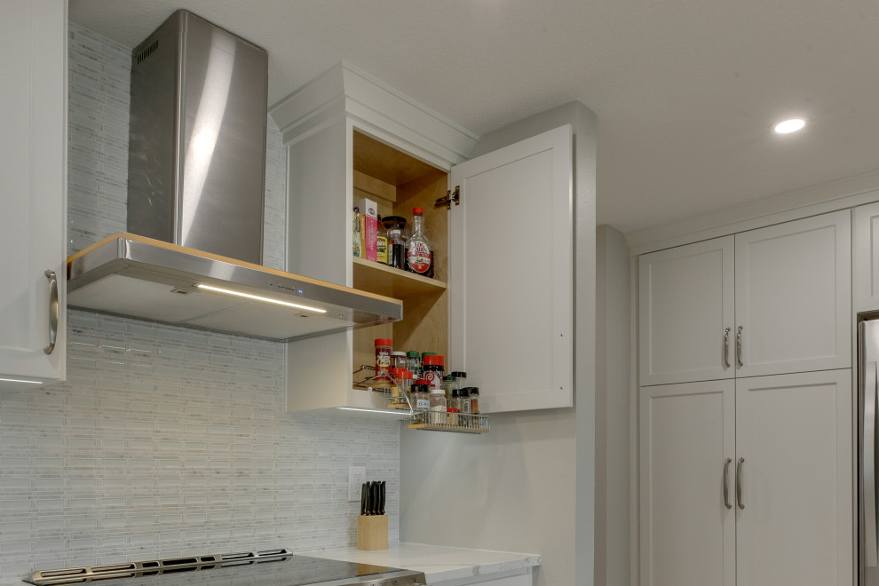 Idéer för ett mellanstort modernt vit kök och matrum, med en enkel diskho, släta luckor, vita skåp, bänkskiva i kvartsit, vitt stänkskydd, ljust trägolv, en köksö och beiget golv