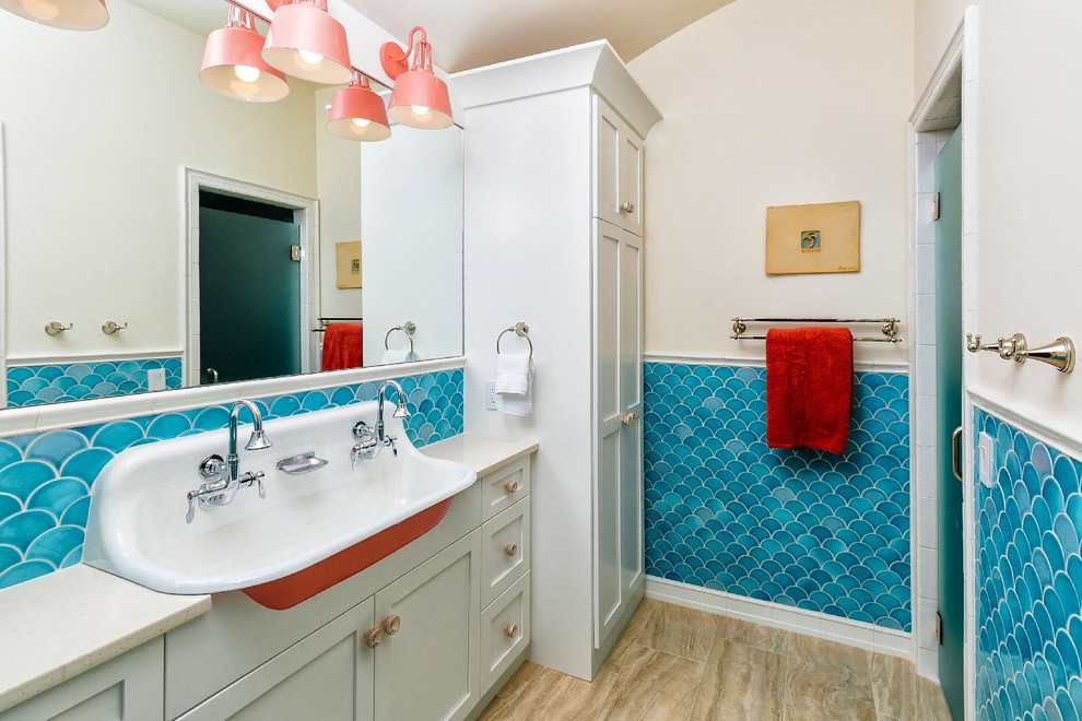 This is an example of a beach style kids bathroom in Charleston with shaker cabinets, beige cabinets, blue tile, beige walls, a trough sink, beige floor and beige benchtops.