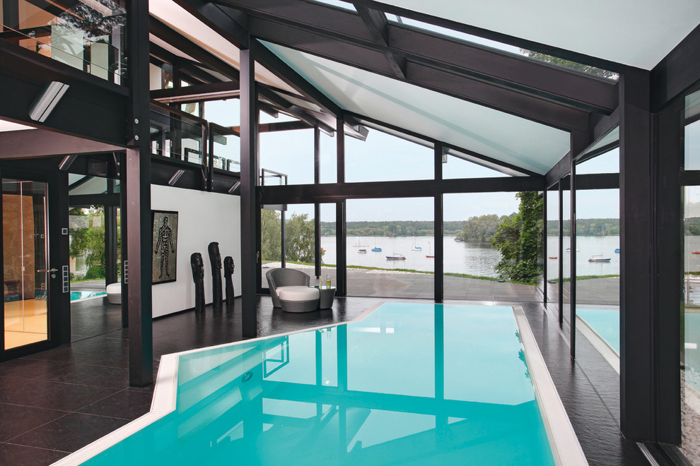 Photo of a large contemporary indoor custom-shaped pool in Stuttgart with tile.