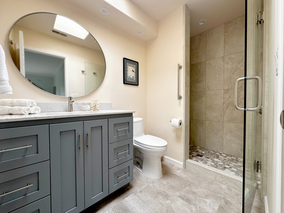 Example of a small transitional 3/4 beige tile and porcelain tile porcelain tile, beige floor and single-sink alcove shower design with shaker cabinets, gray cabinets, a one-piece toilet, beige walls, an undermount sink, quartzite countertops, a hinged shower door, white countertops and a freestanding vanity