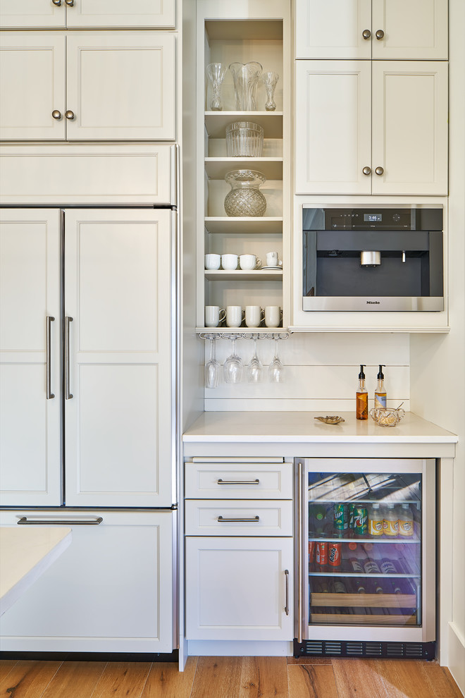 Inspiration for a mid-sized transitional eat-in kitchen in Charleston with a farmhouse sink, shaker cabinets, grey cabinets, granite benchtops, white splashback, timber splashback, stainless steel appliances, light hardwood floors, with island and white benchtop.