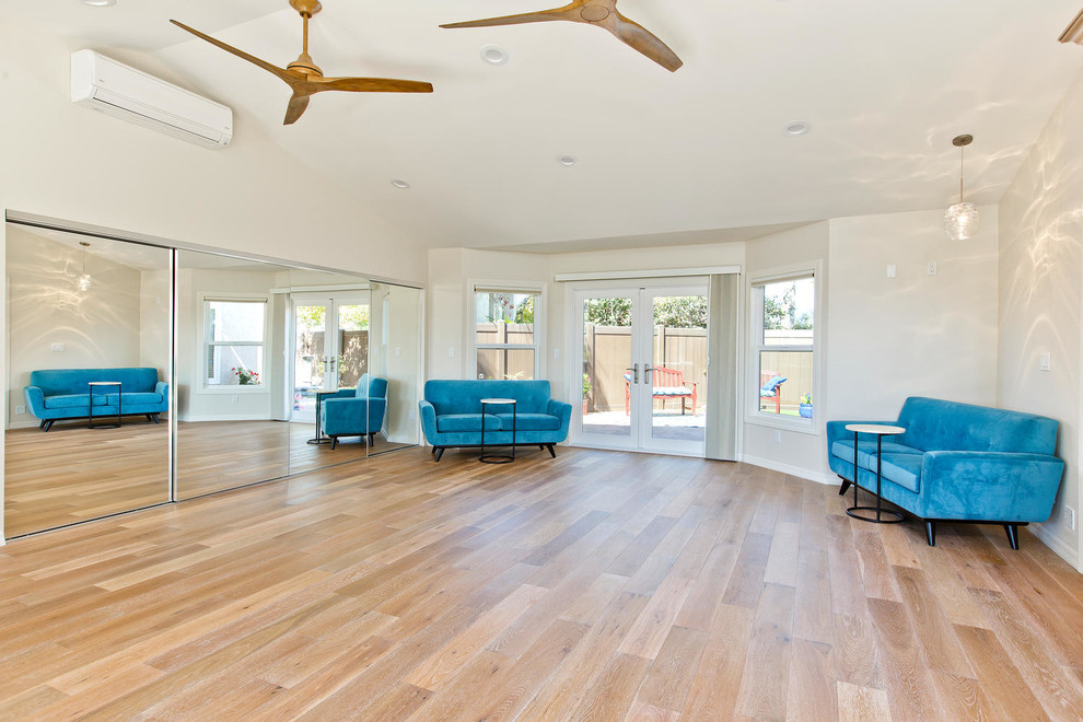 Photo of a large transitional home yoga studio in Tampa with white walls, medium hardwood floors and beige floor.