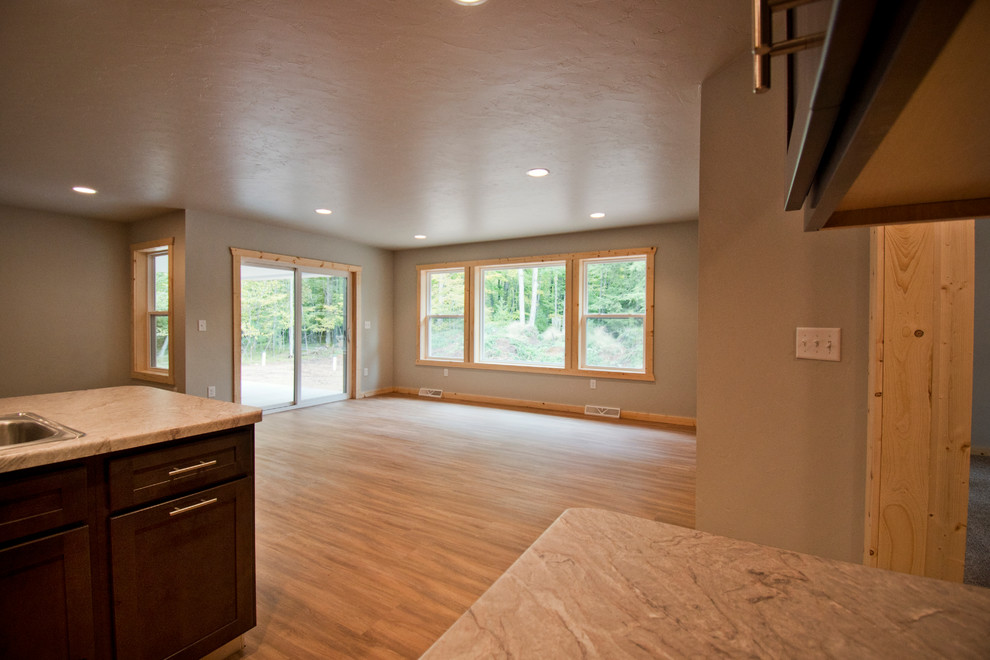 Inspiration for a mid-sized rustic l-shaped medium tone wood floor and brown floor eat-in kitchen remodel with a double-bowl sink, recessed-panel cabinets, dark wood cabinets, an island and gray countertops