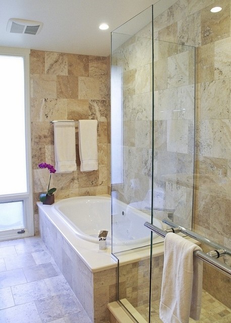Design ideas for a traditional master bathroom in St Louis with a drop-in tub, a corner shower, beige tile, stone tile, beige walls, porcelain floors and a hinged shower door.