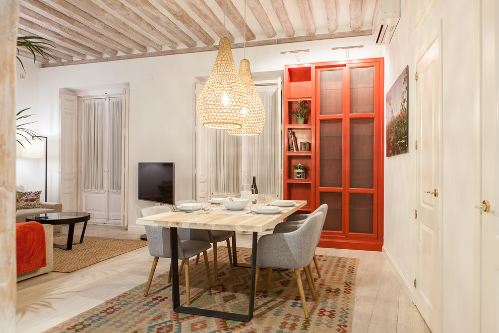 This is an example of a contemporary dining room in Madrid with light hardwood floors.