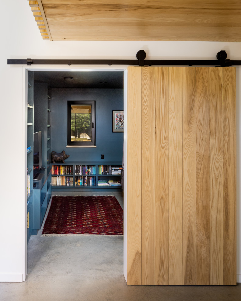 Идея дизайна: маленькая изолированная гостиная комната в стиле модернизм с с книжными шкафами и полками, зелеными стенами, бетонным полом и серым полом для на участке и в саду