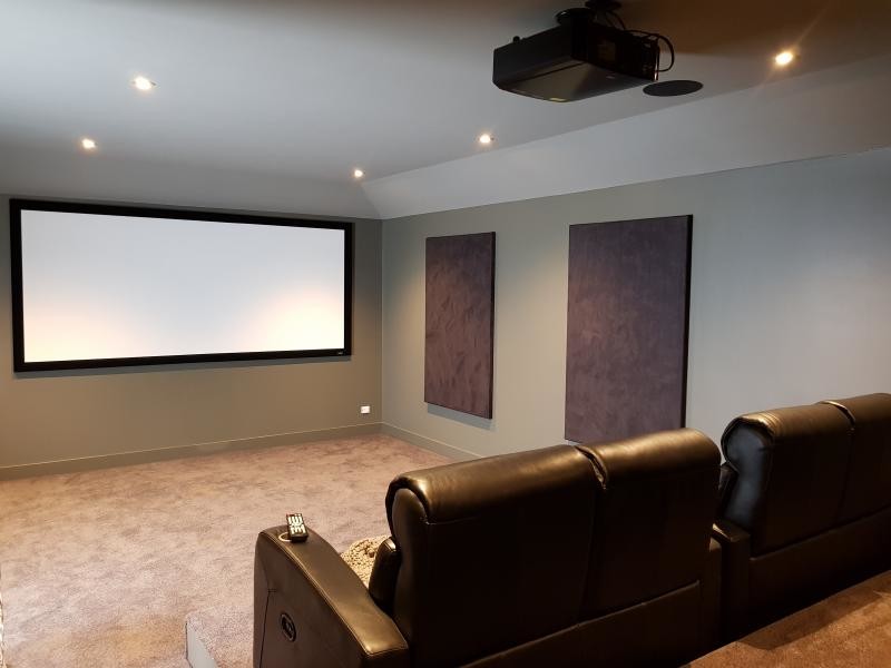 Inspiration for a mid-sized modern enclosed home theatre in Adelaide with green walls, carpet, a projector screen and brown floor.