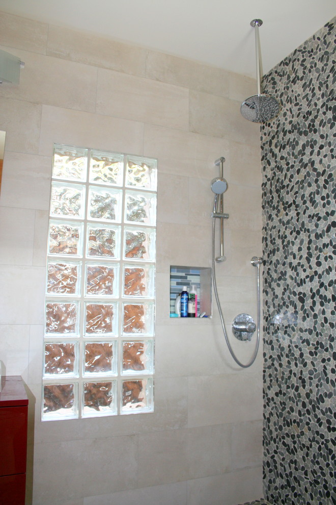 Aménagement d'une petite salle de bain moderne pour enfant avec une vasque, un placard à porte plane, des portes de placard rouges, une douche ouverte, WC séparés, un carrelage gris, une plaque de galets, un mur beige et un sol en galet.