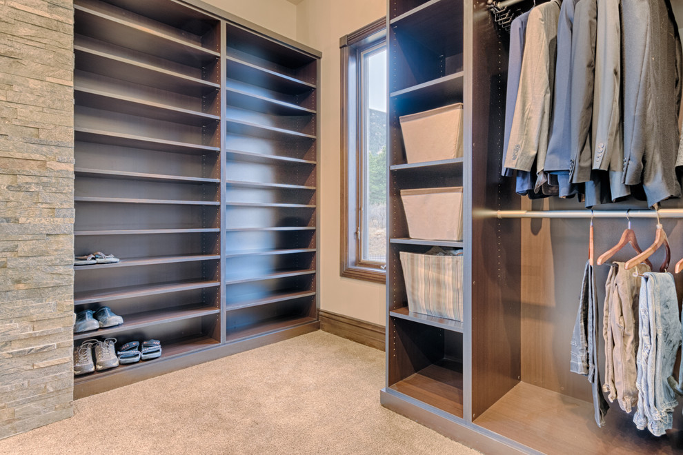 Expansive contemporary gender-neutral dressing room in Denver with flat-panel cabinets, medium wood cabinets and carpet.