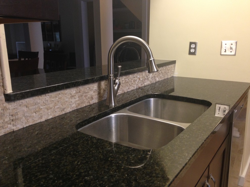 Inspiration for a mid-sized transitional l-shaped porcelain tile enclosed kitchen remodel with an undermount sink, shaker cabinets, dark wood cabinets, granite countertops, beige backsplash, stone tile backsplash, stainless steel appliances and an island