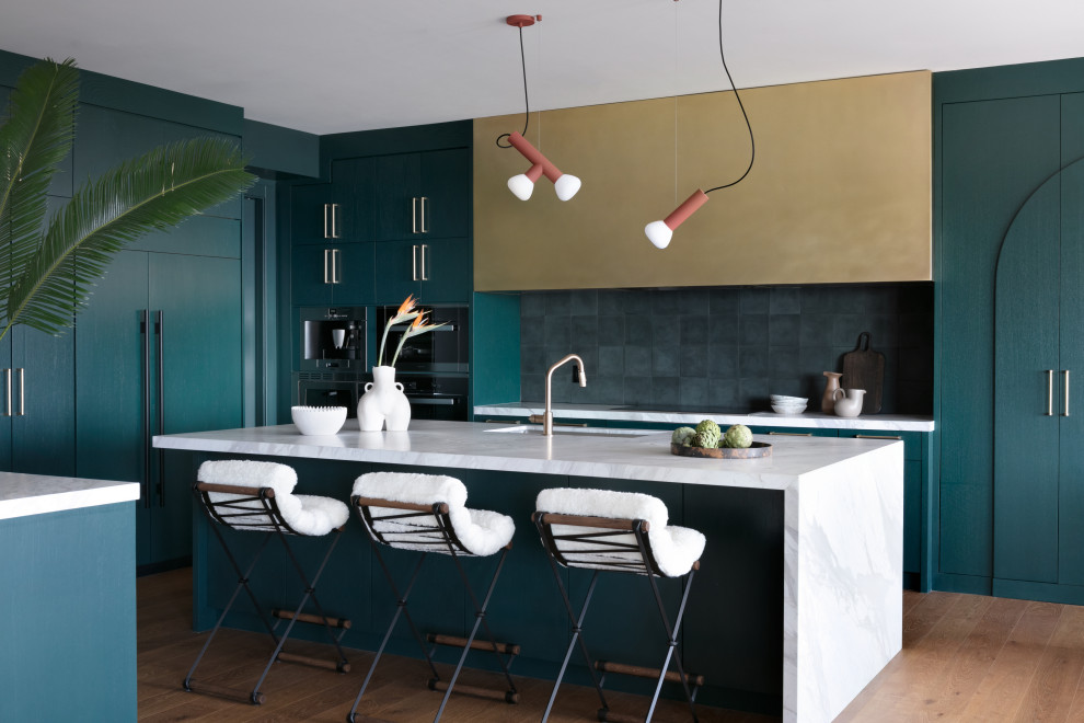 Foto på ett 60 tals vit kök, med släta luckor, marmorbänkskiva, svart stänkskydd, stänkskydd i cementkakel, integrerade vitvaror, mellanmörkt trägolv, en köksö och brunt golv
