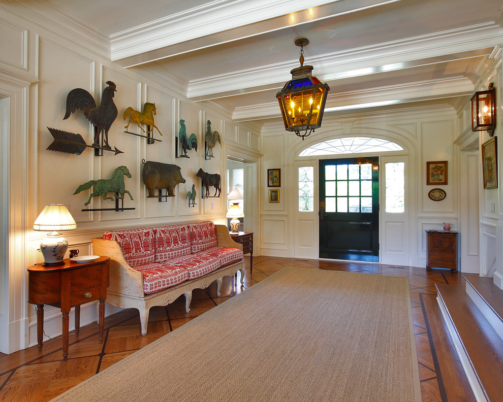 Traditional foyer in New York with white walls, medium hardwood floors, a single front door and a glass front door.