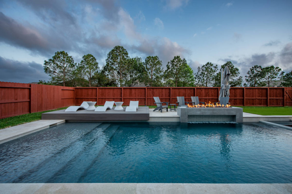 Mittelgroßer Moderner Whirlpool hinter dem Haus in rechteckiger Form mit Natursteinplatten in Houston