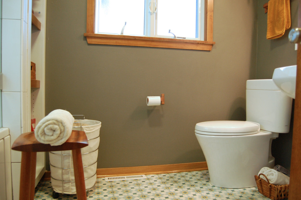 Transitional master white tile ceramic tile and multicolored floor tub/shower combo photo with open cabinets, a two-piece toilet, gray walls, a pedestal sink and a hinged shower door