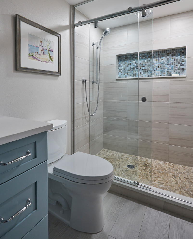 Photo of a small beach style master bathroom in Other with shaker cabinets, blue cabinets, an alcove shower, a two-piece toilet, beige tile, wood-look tile, beige walls, porcelain floors, an undermount sink, engineered quartz benchtops, grey floor, an open shower, beige benchtops, a single vanity and a built-in vanity.