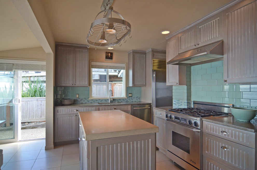 This is an example of a beach style u-shaped eat-in kitchen in Seattle with an undermount sink, beaded inset cabinets, brown cabinets, granite benchtops, subway tile splashback and stainless steel appliances.