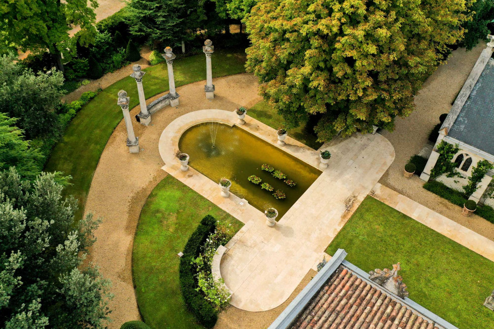 Immagine di un grande giardino classico esposto in pieno sole con pavimentazioni in pietra naturale