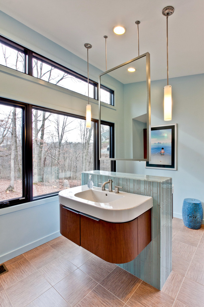 This is an example of a large modern master bathroom in Philadelphia with an integrated sink, flat-panel cabinets, blue tile, porcelain tile, dark wood cabinets, grey walls, porcelain floors and solid surface benchtops.