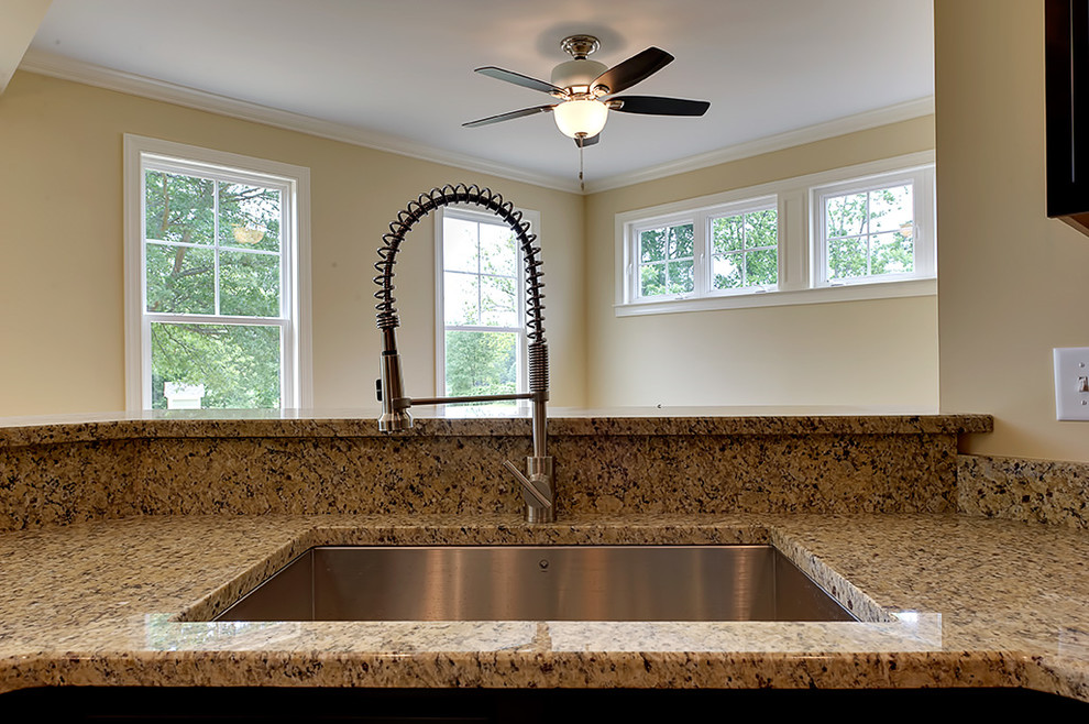 Eat-in kitchen - transitional u-shaped medium tone wood floor eat-in kitchen idea with an undermount sink, granite countertops, recessed-panel cabinets, dark wood cabinets and an island