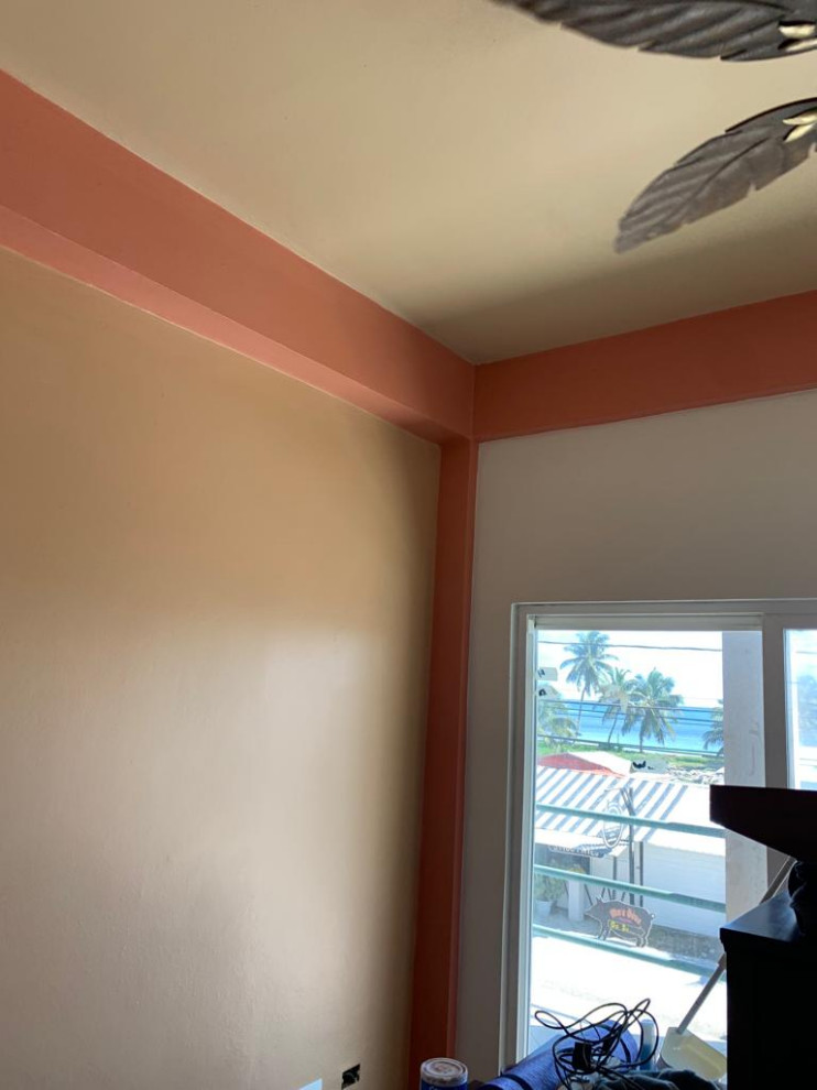 Mittelgroßes Gästezimmer mit oranger Wandfarbe, Porzellan-Bodenfliesen, beigem Boden und freigelegten Dachbalken in Las Vegas