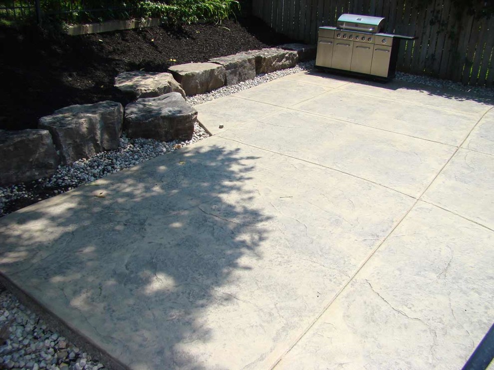 Design ideas for a mid-sized traditional backyard patio in Toronto with stamped concrete.