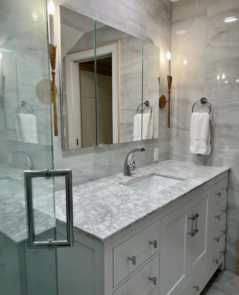Mid-sized transitional master gray tile and ceramic tile ceramic tile, gray floor and single-sink corner shower photo in Other with shaker cabinets, white cabinets, a bidet, gray walls, an undermount sink, marble countertops, a hinged shower door, gray countertops, a niche and a freestanding vanity