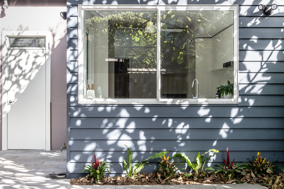 Photo of a small contemporary one-storey grey house exterior in Sydney with concrete fiberboard siding.