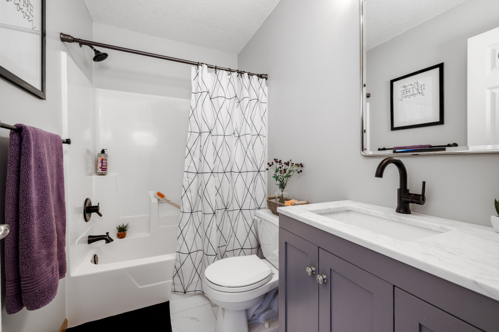 Photo of a small 3/4 bathroom in Minneapolis with shaker cabinets, grey cabinets, an alcove tub, a shower/bathtub combo, a two-piece toilet, grey walls, vinyl floors, an undermount sink, engineered quartz benchtops, white floor, a shower curtain, white benchtops, a single vanity and a freestanding vanity.