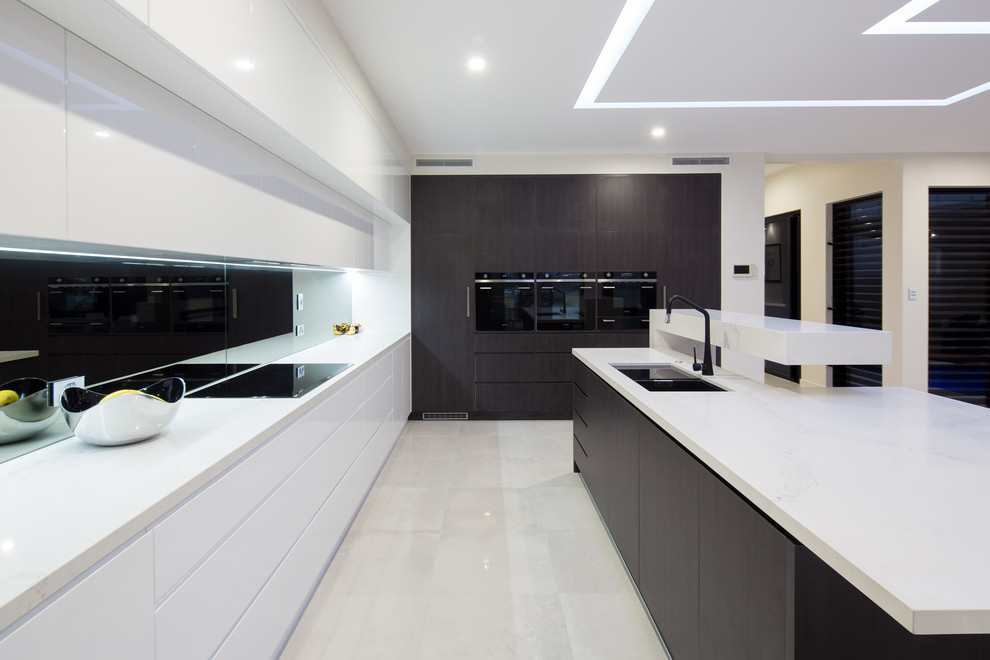 This is an example of a contemporary kitchen in Brisbane with a double-bowl sink, flat-panel cabinets, dark wood cabinets, black appliances and with island.
