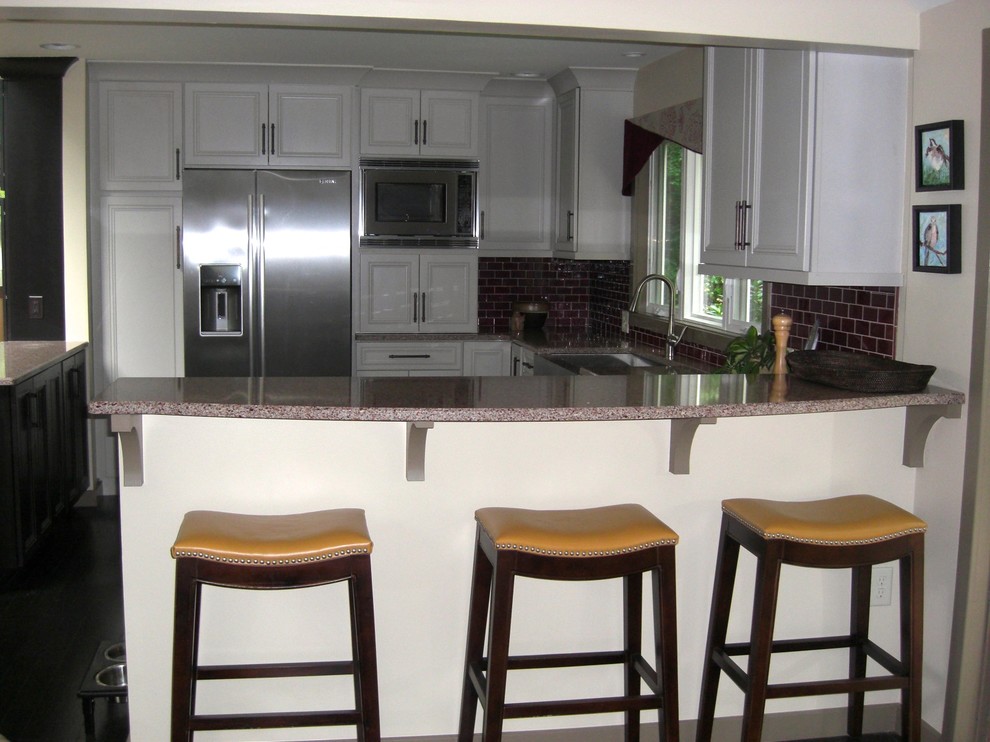 Inspiration for a transitional eat-in kitchen remodel in Philadelphia with an undermount sink, recessed-panel cabinets, white cabinets, quartz countertops, glass tile backsplash and stainless steel appliances