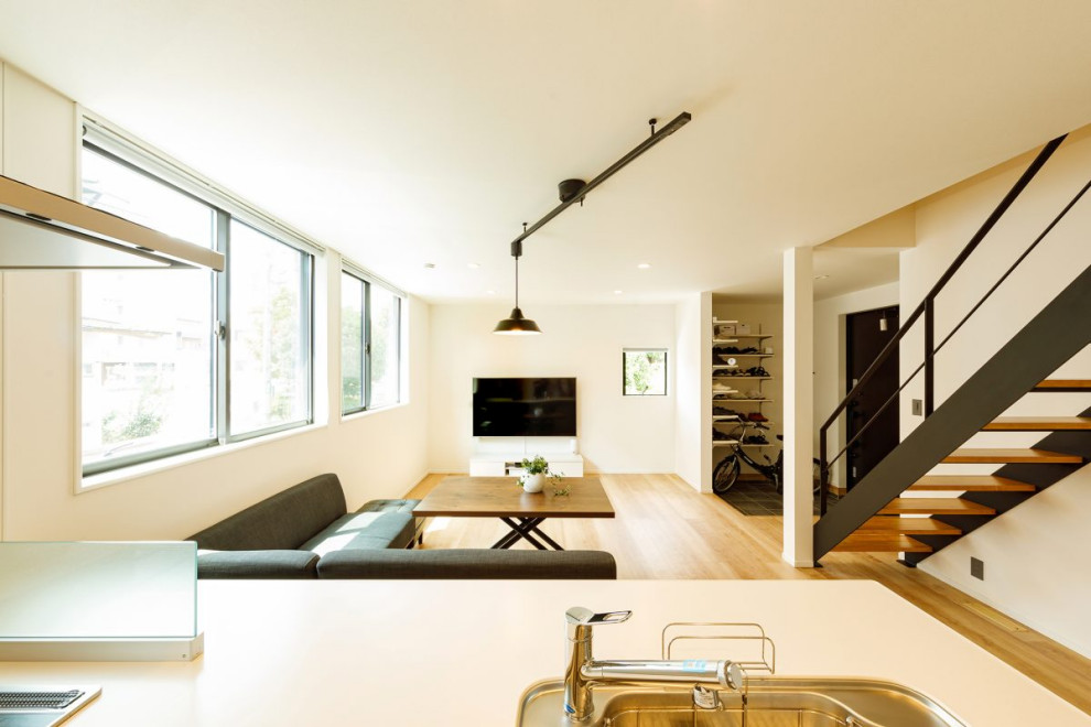 This is an example of a mid-sized industrial open plan dining in Tokyo Suburbs with white walls, light hardwood floors, no fireplace, beige floor, wallpaper and wallpaper.