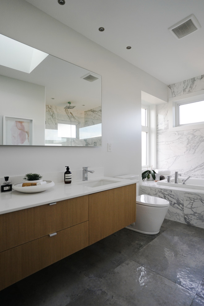 This is an example of a mid-sized contemporary master bathroom in Vancouver with white tile, marble, white walls, ceramic floors, a drop-in sink, grey floor, a hinged shower door, white benchtops and a built-in vanity.