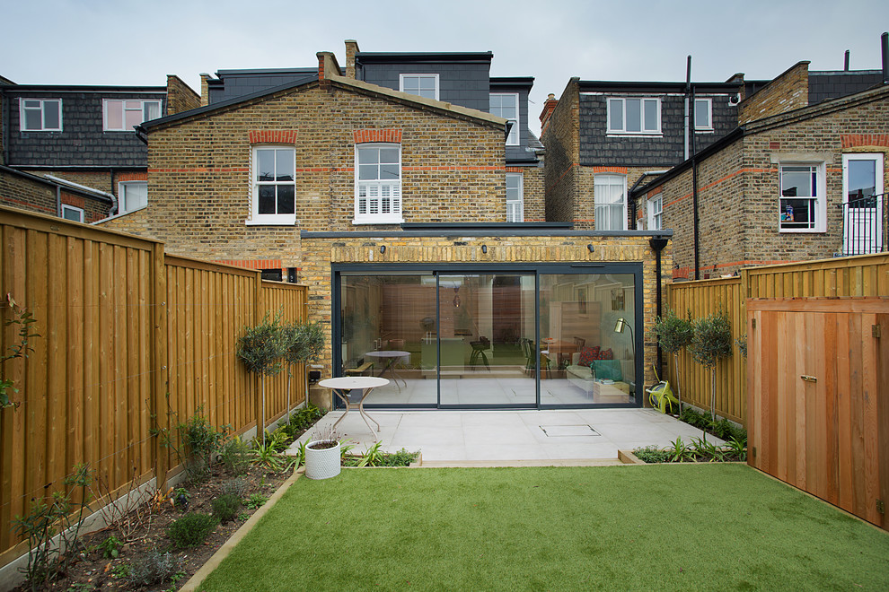 Inspiration for a contemporary split-level brick brown house exterior in London with a mixed roof.