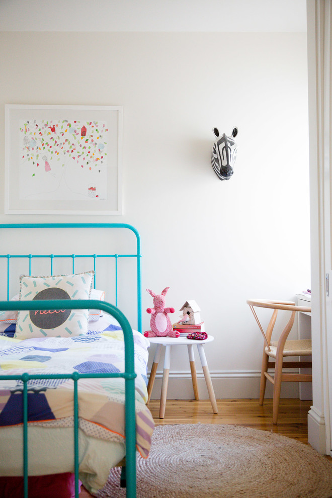 This is an example of a contemporary kids' bedroom for girls in Sydney with white walls and medium hardwood floors.