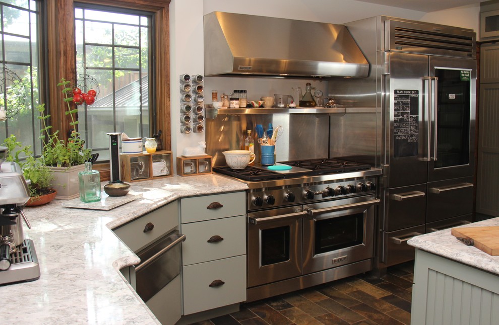 Inspiration for a traditional kitchen in Chicago with a triple-bowl sink, recessed-panel cabinets, green cabinets, quartz benchtops, stainless steel appliances, slate floors and with island.