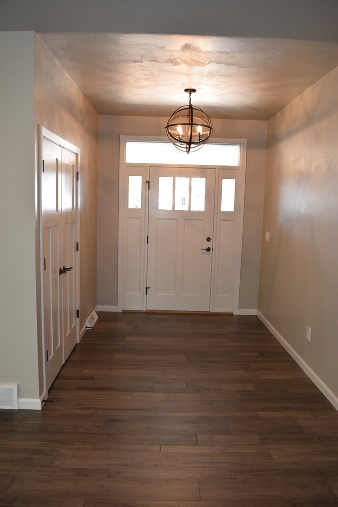 Inspiration for a medium tone wood floor entryway remodel with a white front door