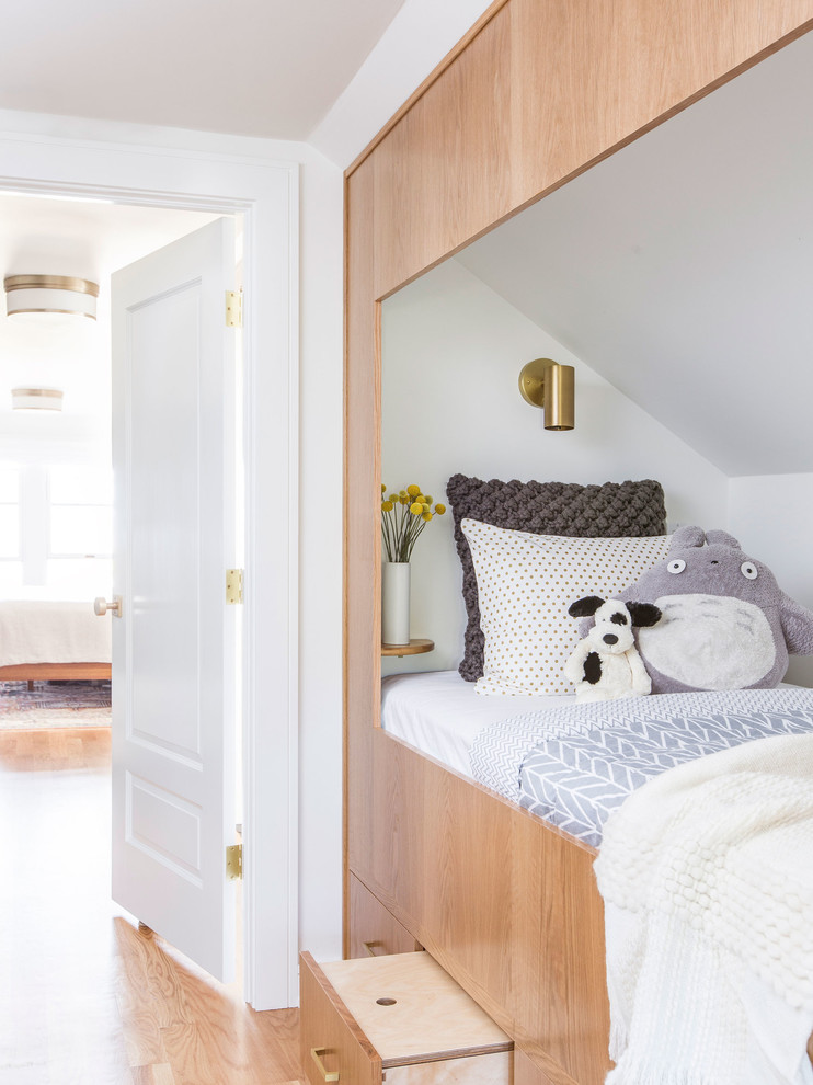 Photo of a transitional gender-neutral kids' bedroom in Portland with white walls, medium hardwood floors and brown floor.