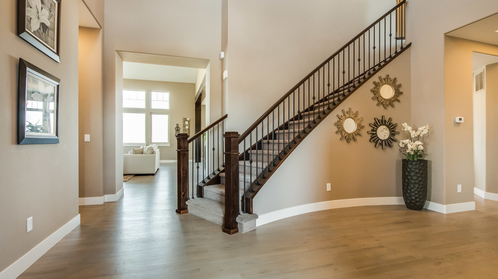 Design ideas for a large transitional carpeted curved staircase in Denver with carpet risers.