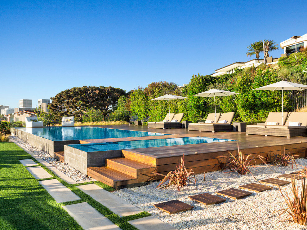 Photo of a contemporary backyard rectangular infinity pool in Orange County with a hot tub and decking.