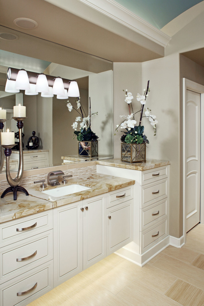 Photo of a large transitional master bathroom in Other with raised-panel cabinets, white cabinets, beige tile, matchstick tile, beige walls, laminate floors, an undermount sink, onyx benchtops, beige floor and beige benchtops.