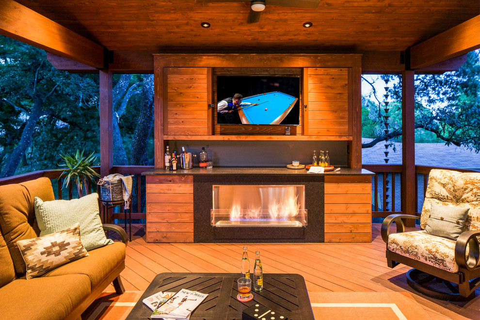 Mid-sized contemporary backyard deck in Austin with a fire feature and a roof extension.