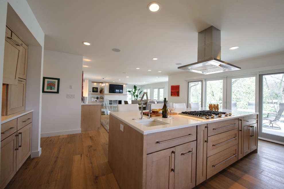 Mid-sized contemporary galley open plan kitchen in Indianapolis with an undermount sink, shaker cabinets, light wood cabinets, quartzite benchtops, white splashback, stainless steel appliances, light hardwood floors and with island.