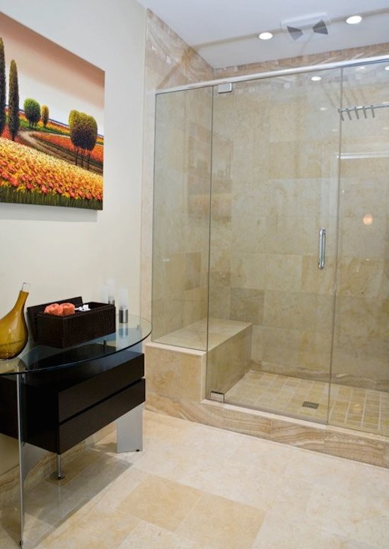Photo of a large contemporary master bathroom in Atlanta with glass-front cabinets, dark wood cabinets, an alcove shower, beige tile, stone tile, white walls, ceramic floors, glass benchtops, beige floor and a hinged shower door.