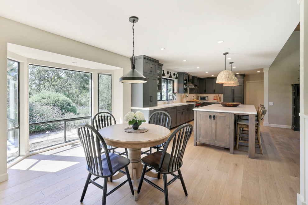 Open concept kitchen - mid-sized transitional l-shaped laminate floor open concept kitchen idea with a double-bowl sink, flat-panel cabinets, gray cabinets, quartz countertops, white backsplash, ceramic backsplash, stainless steel appliances, an island and white countertops