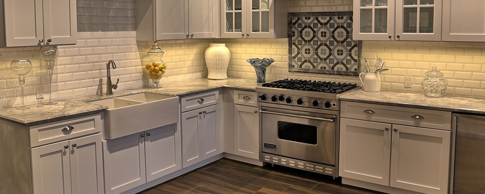 Design ideas for a traditional kitchen in Denver with a farmhouse sink, shaker cabinets, white cabinets, marble benchtops, white splashback, subway tile splashback, stainless steel appliances, porcelain floors and brown floor.