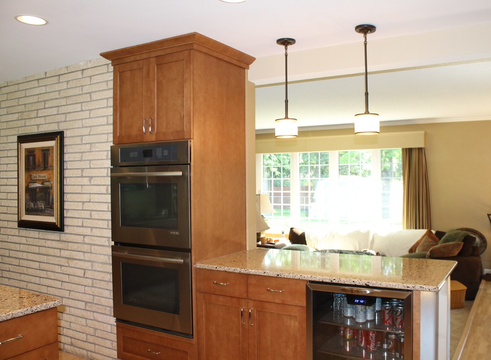 Mid-sized transitional u-shaped eat-in kitchen photo with shaker cabinets, medium tone wood cabinets, quartzite countertops and a peninsula