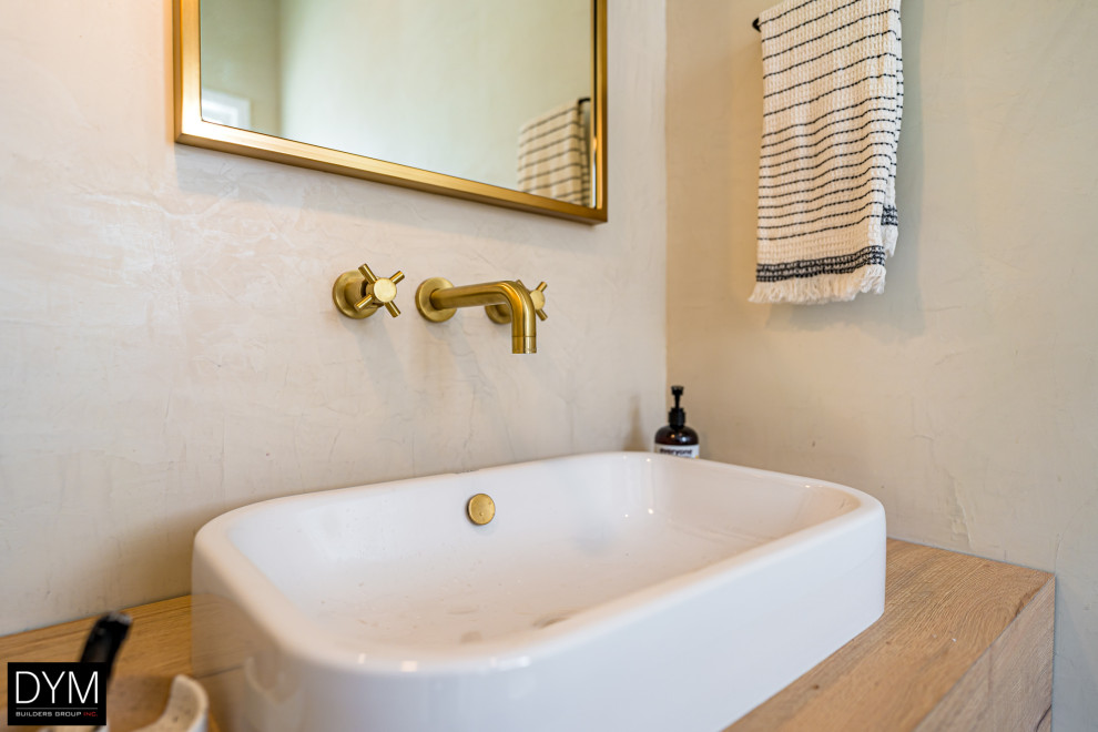 Inredning av ett rustikt brun brunt badrum med dusch, med släta luckor, skåp i mellenmörkt trä, beige kakel, beige väggar, klinkergolv i keramik, träbänkskiva, lila golv och ett fristående handfat